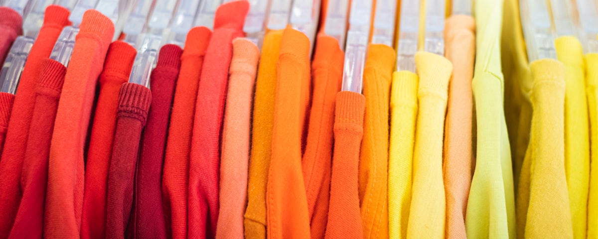 Colorful shirts sorted by color on a rack